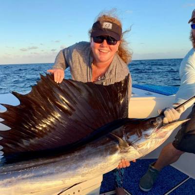 a man holding a fish in the water