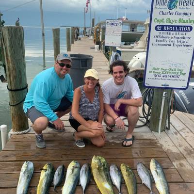 a man holding a fish on a wooden bench
