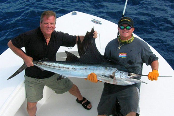 a man holding a fish in the water
